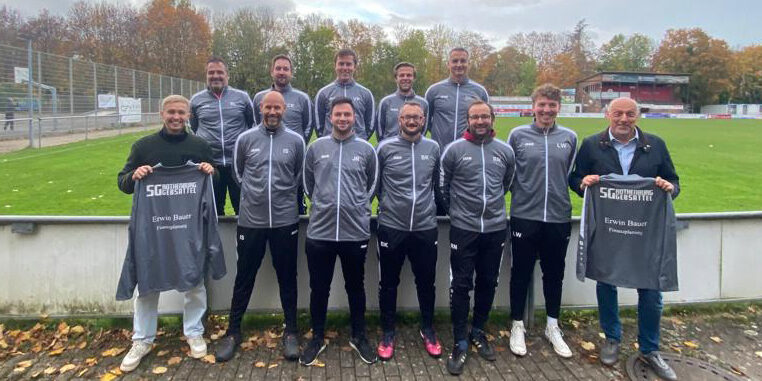 Jugendtrainer erhalten einheitliche Outfits Gruppenfoto der Jugendtrainer